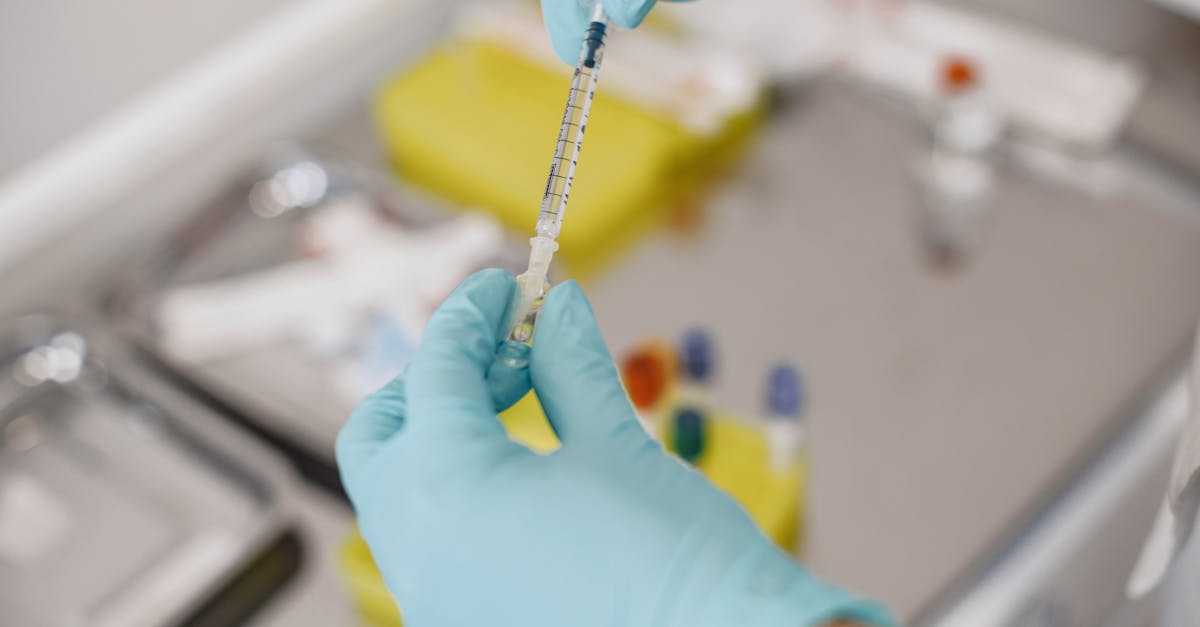 A close-up of gloved hands preparing a syringe in a medical lab setting, emphasizing hygiene and precision.