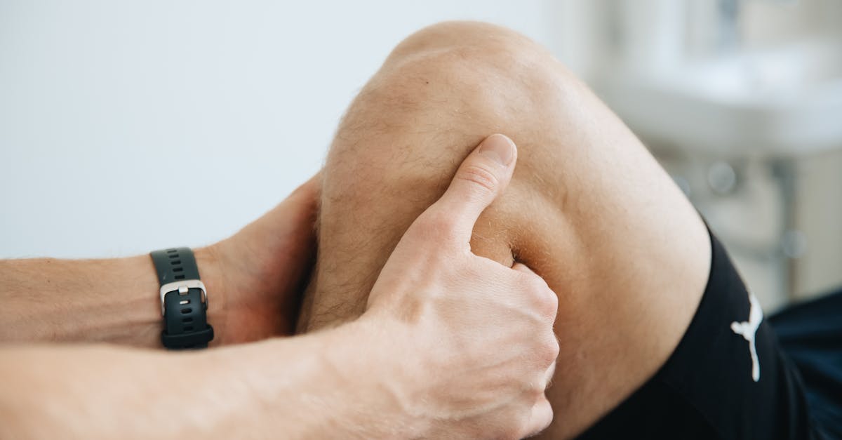 Close-up of a physiotherapist massaging a patient's knee during therapy.