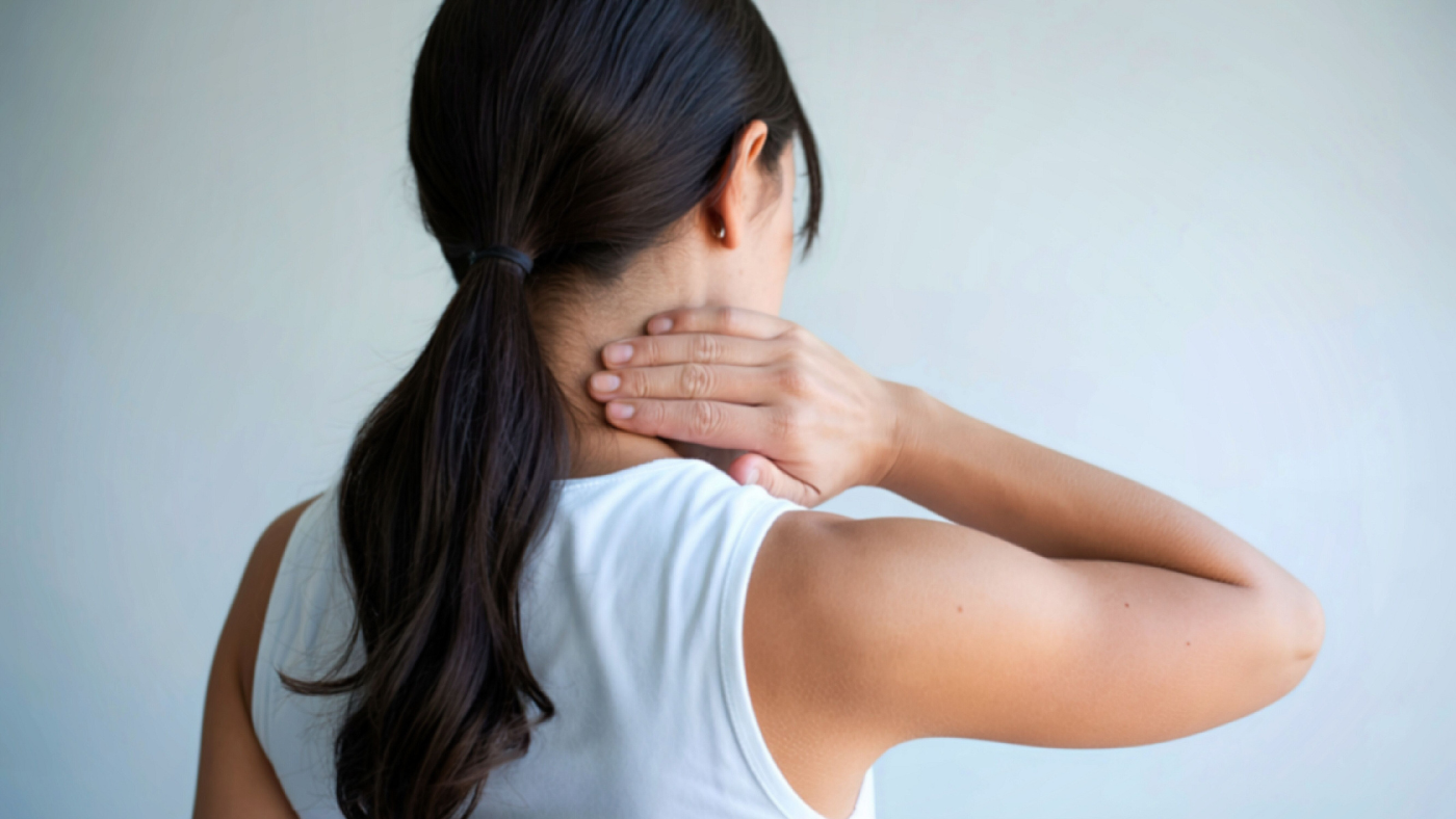 Woman holding the back of her neck in pain after a car accident soft tissue injury