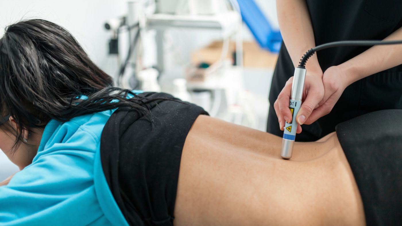 Patient undergoing Class IV laser therapy treatment for lower back pain at OC Wellness Physicians Medical Group