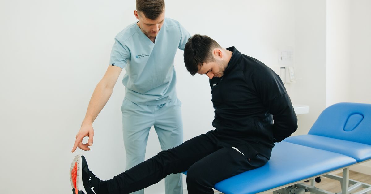 Physiotherapist instructing a patient on rehabilitation exercises in a clinic setting.