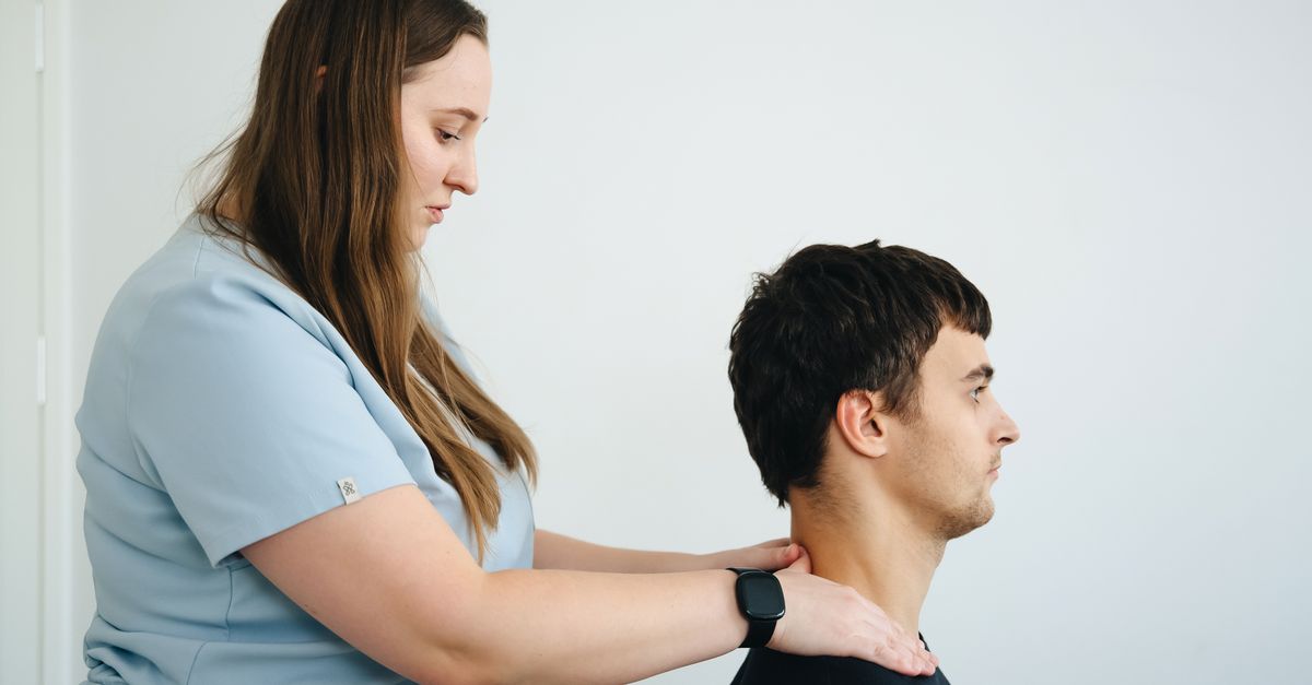 A physiotherapist treating neck pain on a patient in a clinic setting with a focus on healthcare.