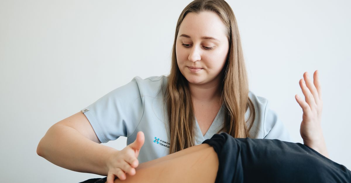 Female physiotherapist providing massage therapy to a patient in a clinic setting.